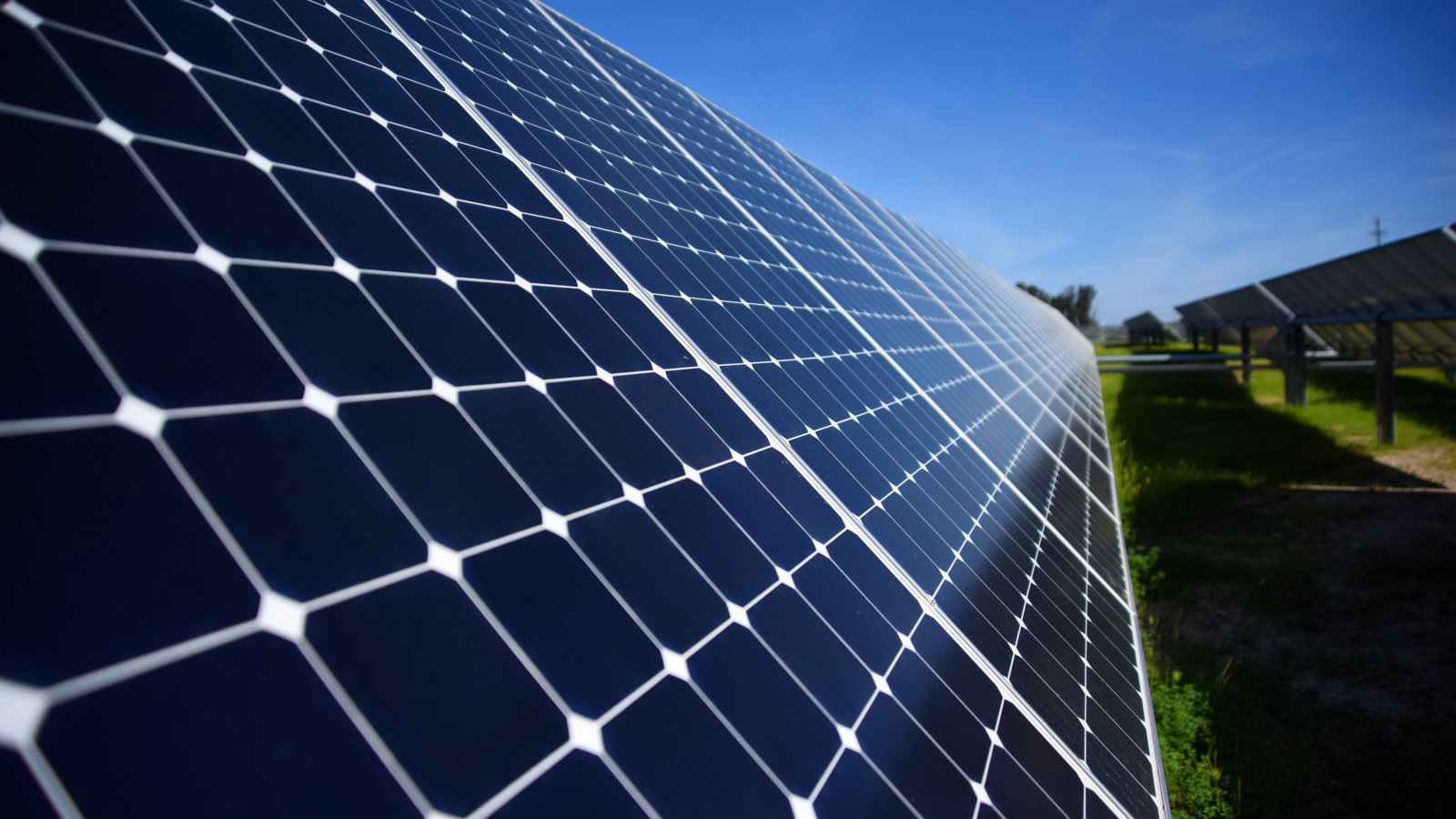 Rows of solar panels under a blue sky at Vandenberg Air Force Base.