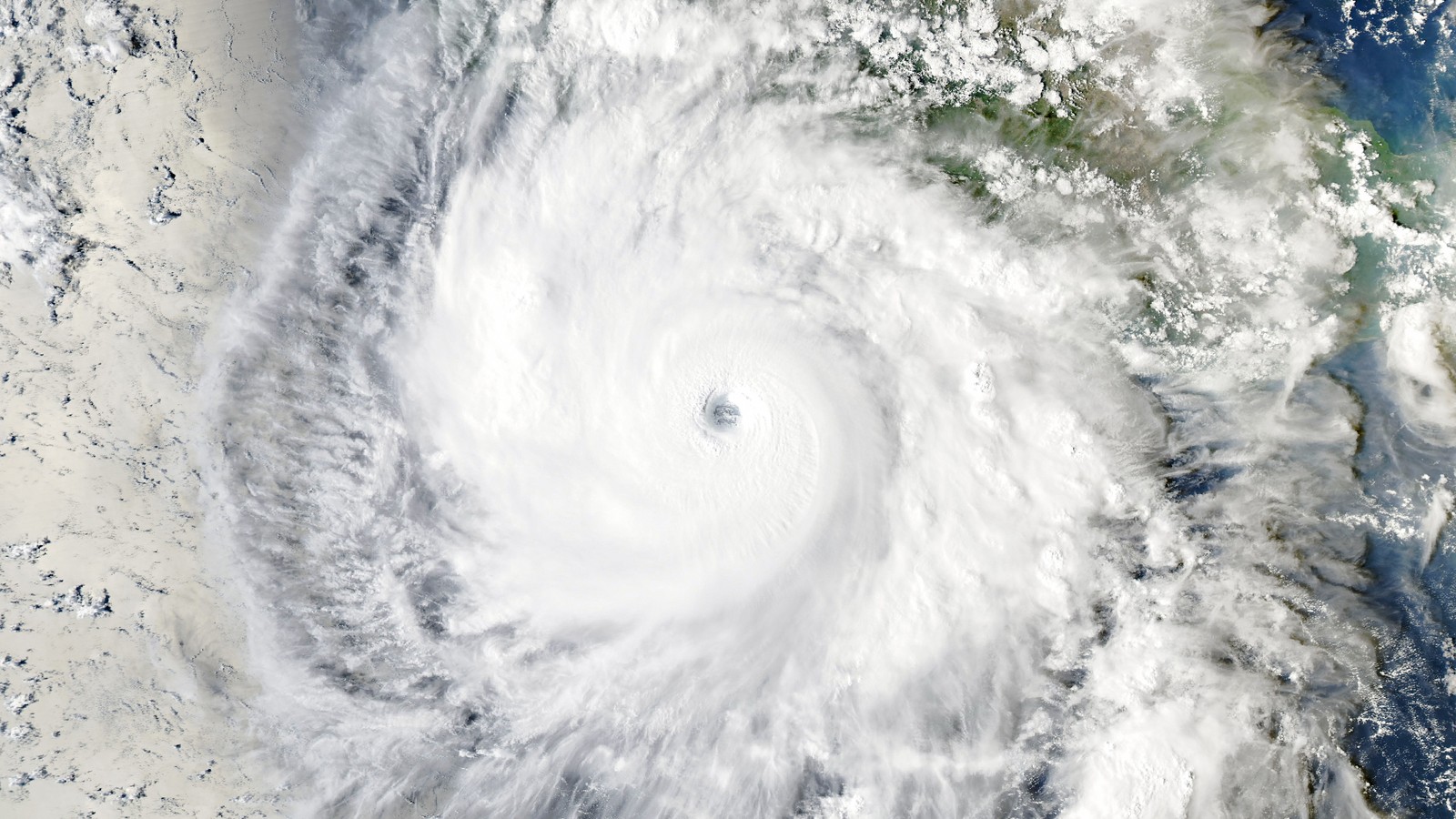 NASA Aqua MODIS natural color satellite image of Hurricane Polo on the afternoon of Sep 23 2026, about 6:15 PM EDT: a vast spiral of white cloud with a small, sharp eye, off the coast of Guerrero, Mexico, whose green coastline shows at upper right.
