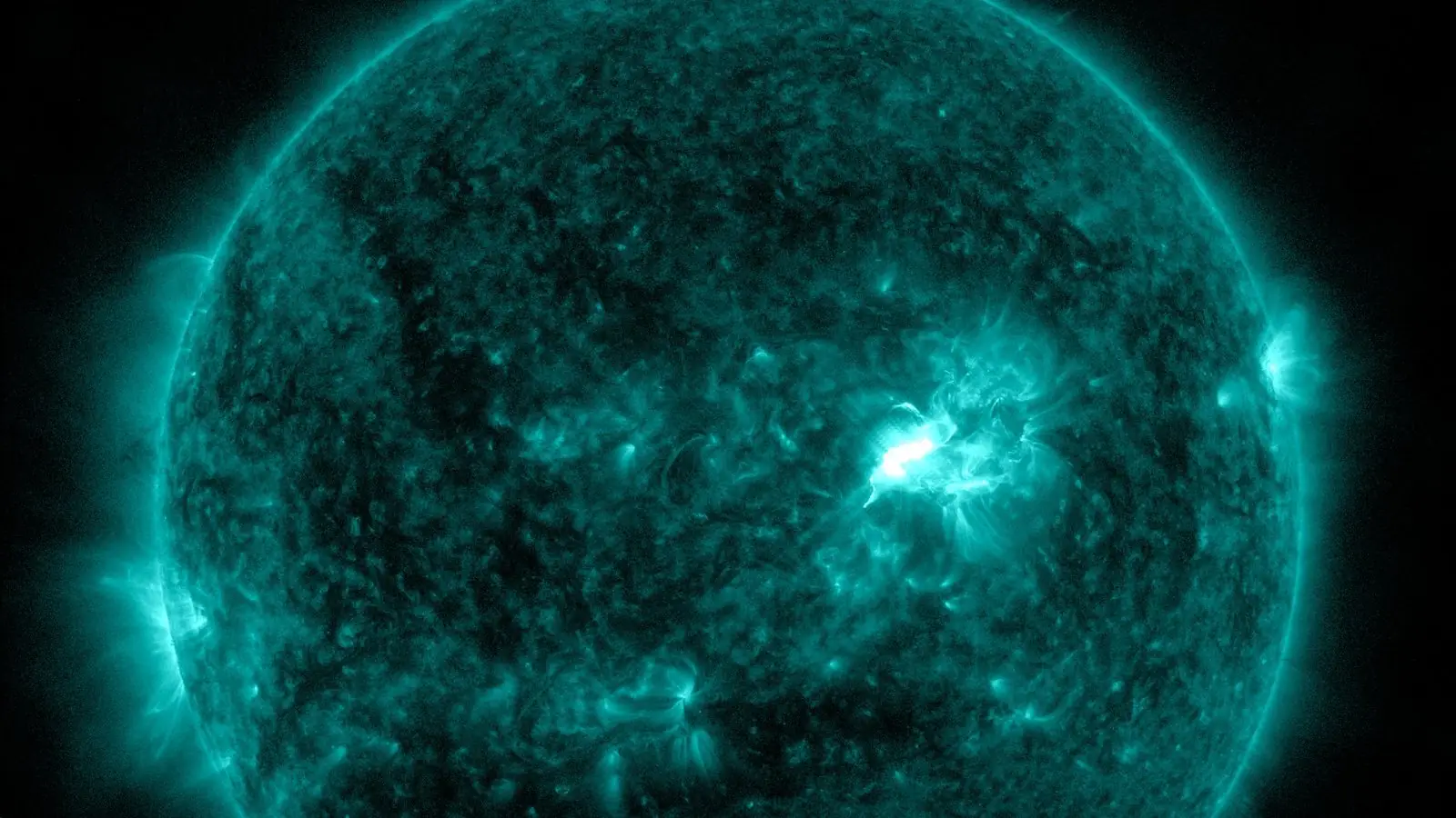 NASA SDO extreme-ultraviolet image of the Sun at 11:43 AM EDT Oct 8, 2026, in the 131-angstrom channel: a bright flare lights up sunspot Region 4549 just north and west of disk centre, five minutes before the M6.7 flare peaked.