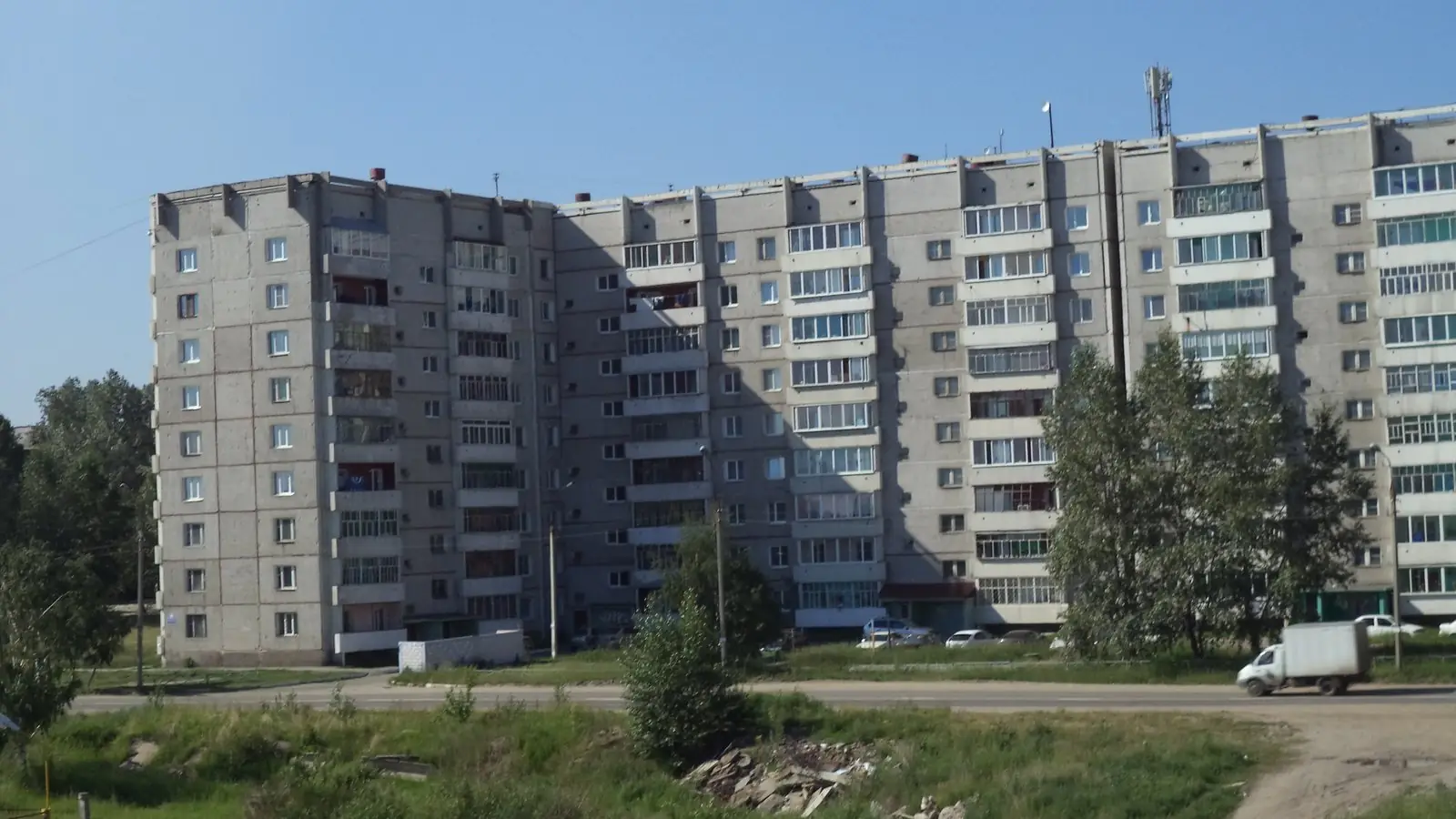 File photo from July 2013: nine-story apartment blocks on Beloborodova Street in Shelekhov, Irkutsk region, under a clear sky. Not an image of the hospital or the institute.